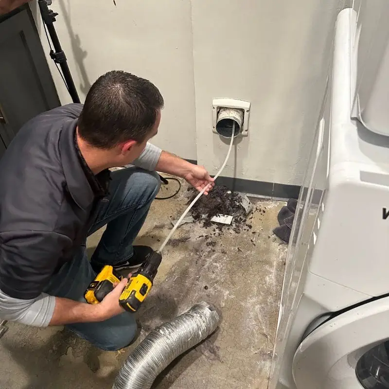 PowerOn Appliance Repair Service technician cleaning dryer vent in The Woodlands, TX.