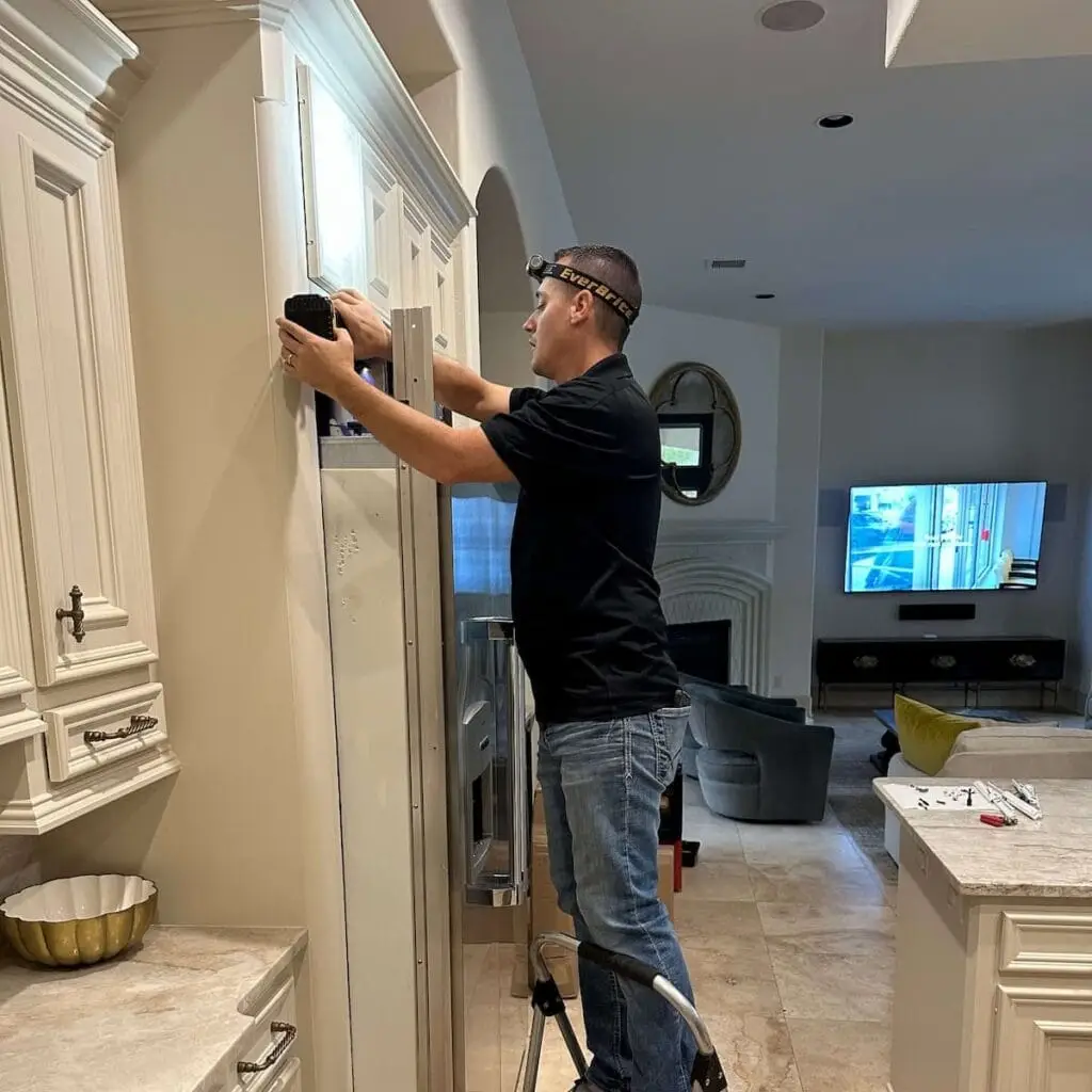 PowerOn Appliance Repair Service technician servicing built in Thermador refrigerator in The Woodlands, TX.