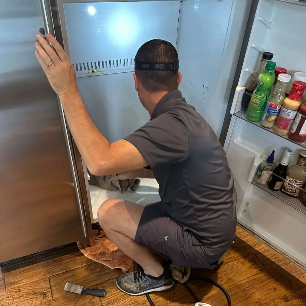 PowerOn Appliance Repair Service technician servicing Sub-Zero refrigerator in The Woodlands, TX.