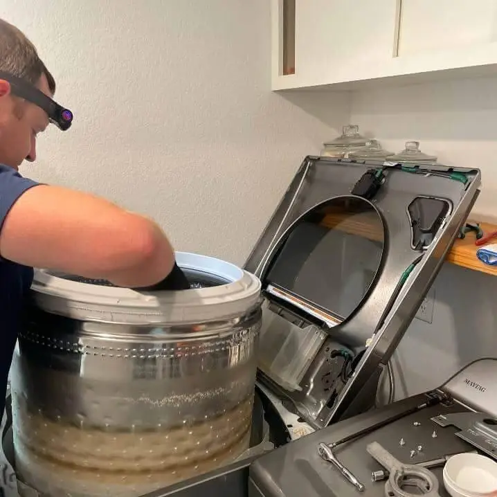 PowerOn Appliance Repair Service technician servicing Whirlpool top load washer in The Woodlands, TX.