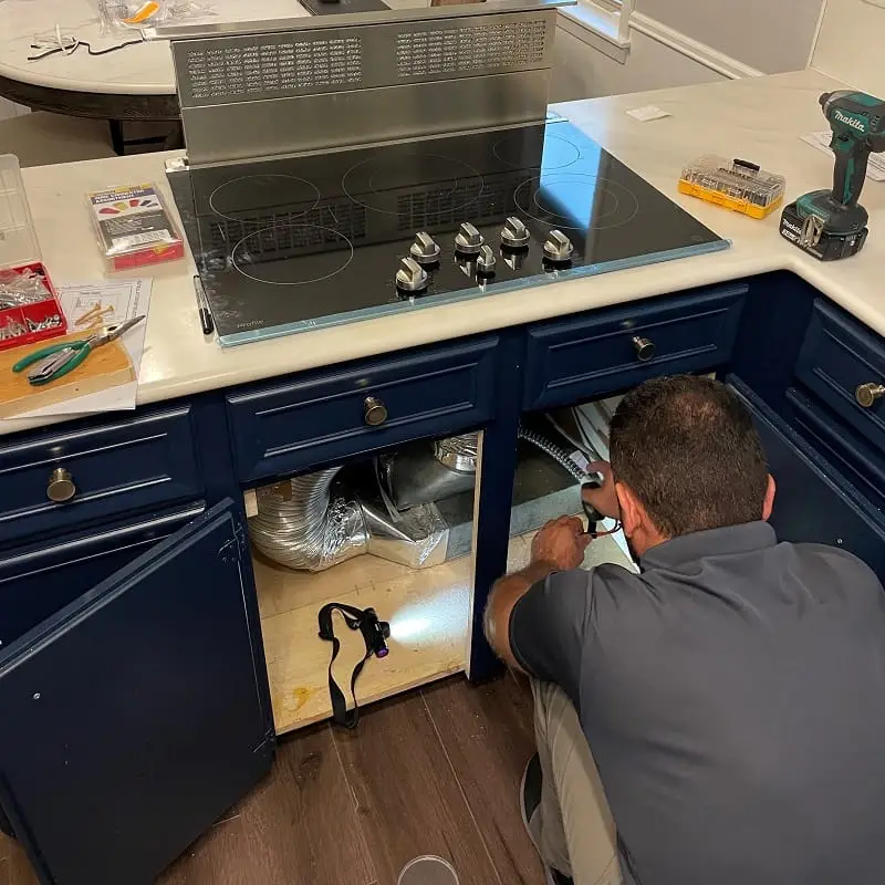 PowerOn Appliance Repair Service technician installing Downdraft and cooktop