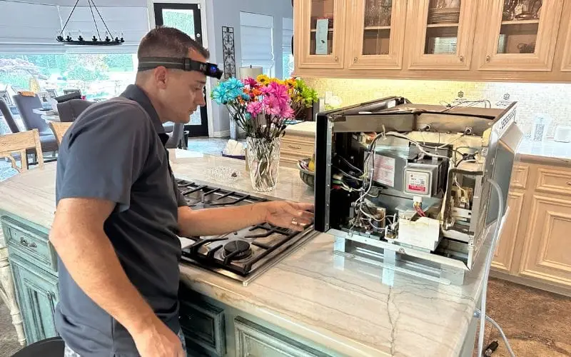 PowerOn Appliance Repair Service technician working on microwave