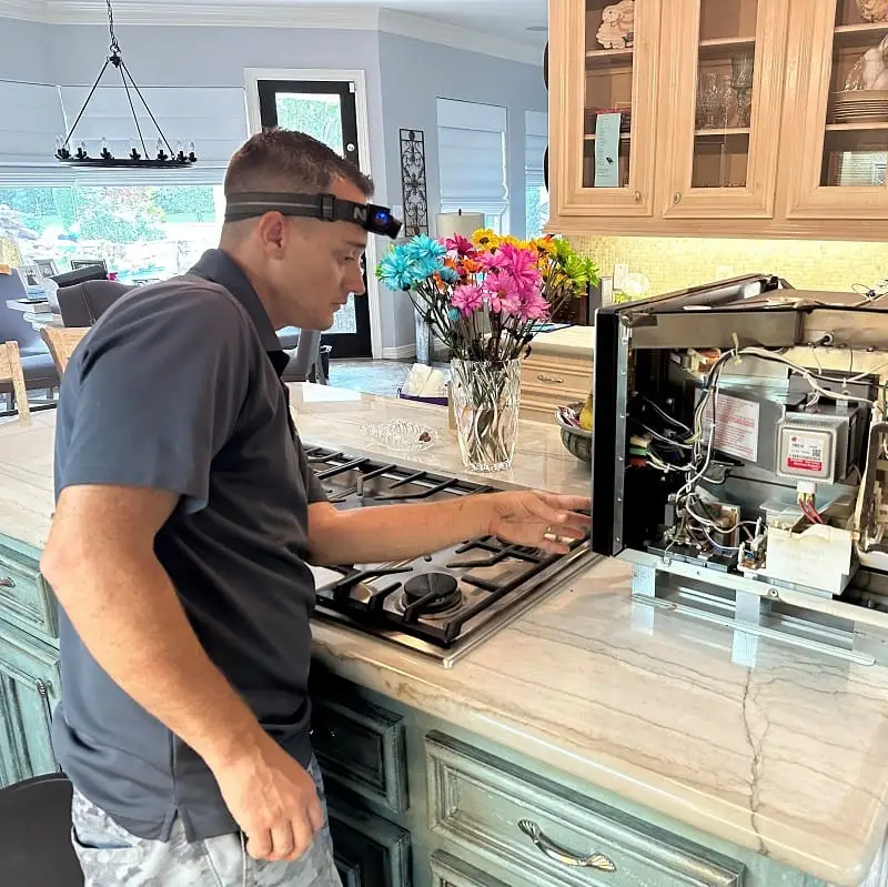 PowerOn Appliance Repair Service technician working on KitchenAid microwave