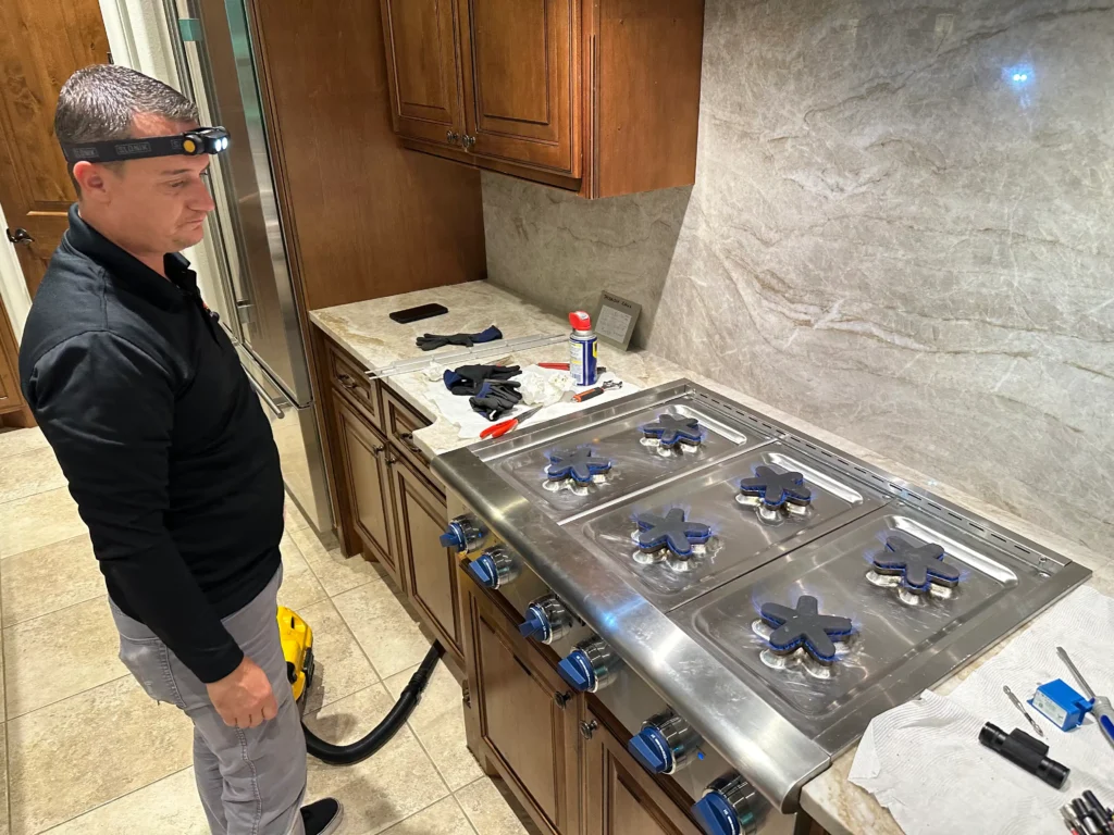 PowerOn Appliance Repair Service technician servicing Thermador cooktop in The Woodlands, TX
