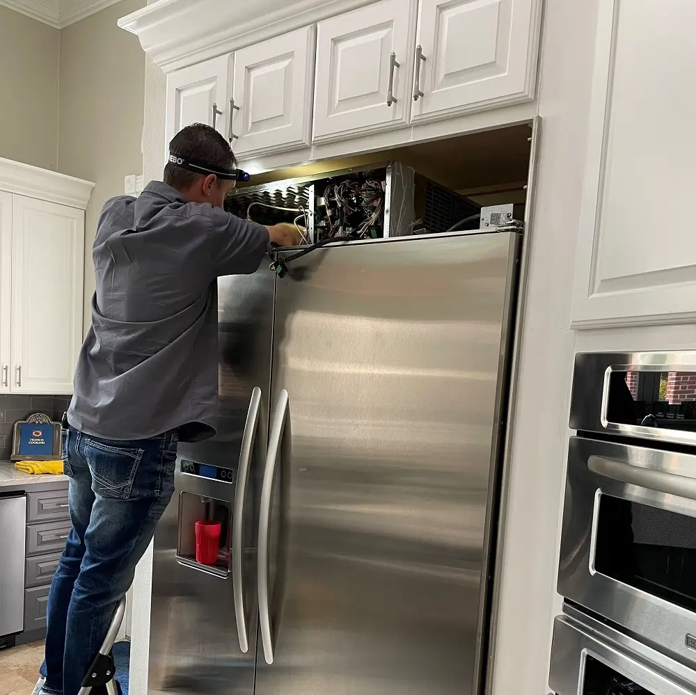 PowerOn Appliance Repair Service technician working on KitchenAid built-in refrigerator