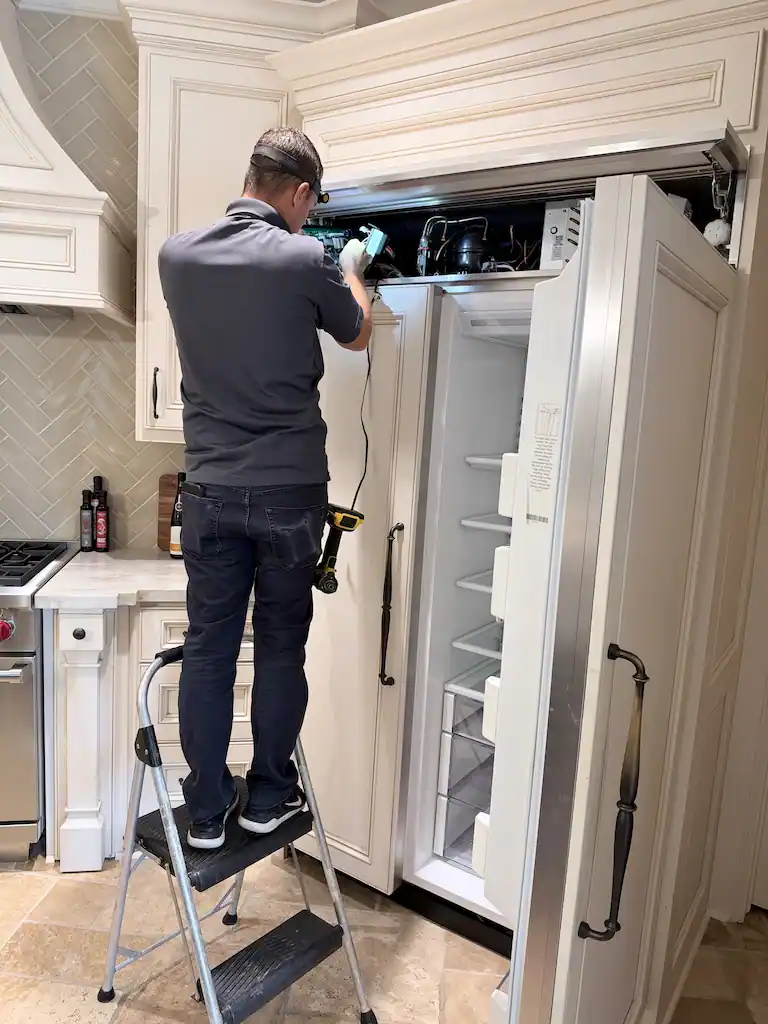 PowerOn technician diagnosing and replacing a Sub-Zero refrigerator main control board in The Woodlands, TX.
